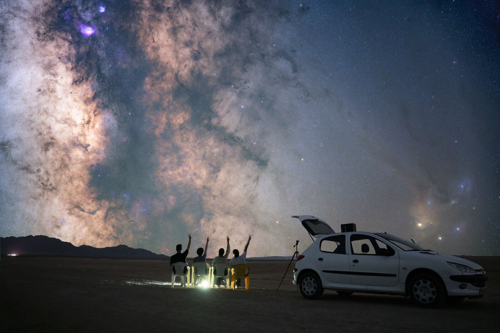 Un groupe de personnes observe le ciel étoilé depuis un site dégagé