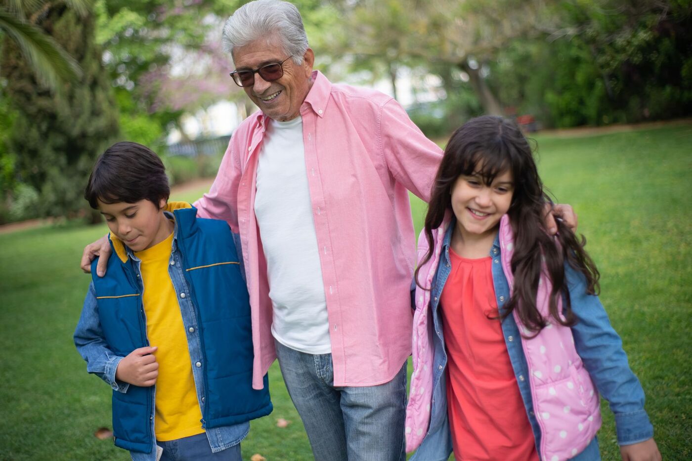 Grand-père marchant avec ses petits-enfants dans un parc