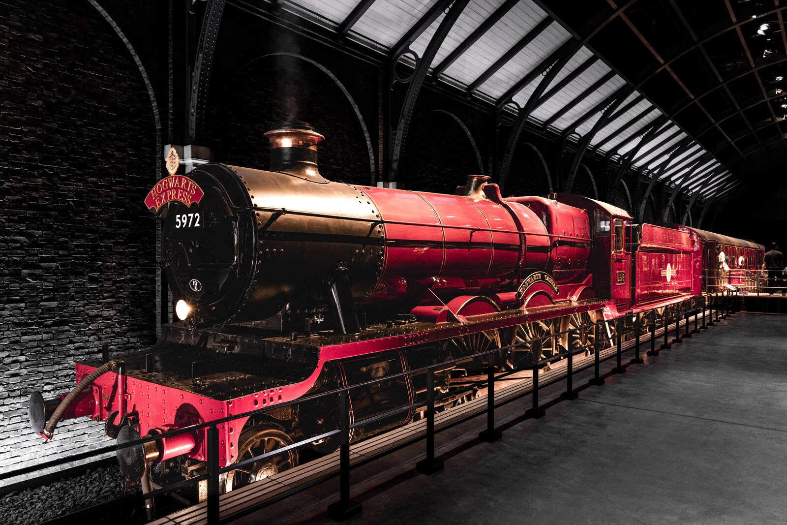 Décor de gare avec une locomotive rouge dans une exposition en intérieur