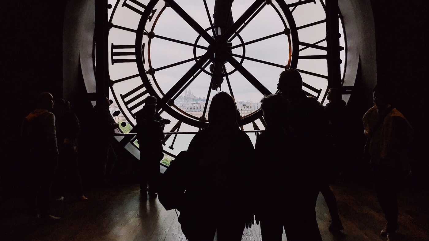Visiteurs observant Paris à travers la grande horloge en verre du musée d'Orsay