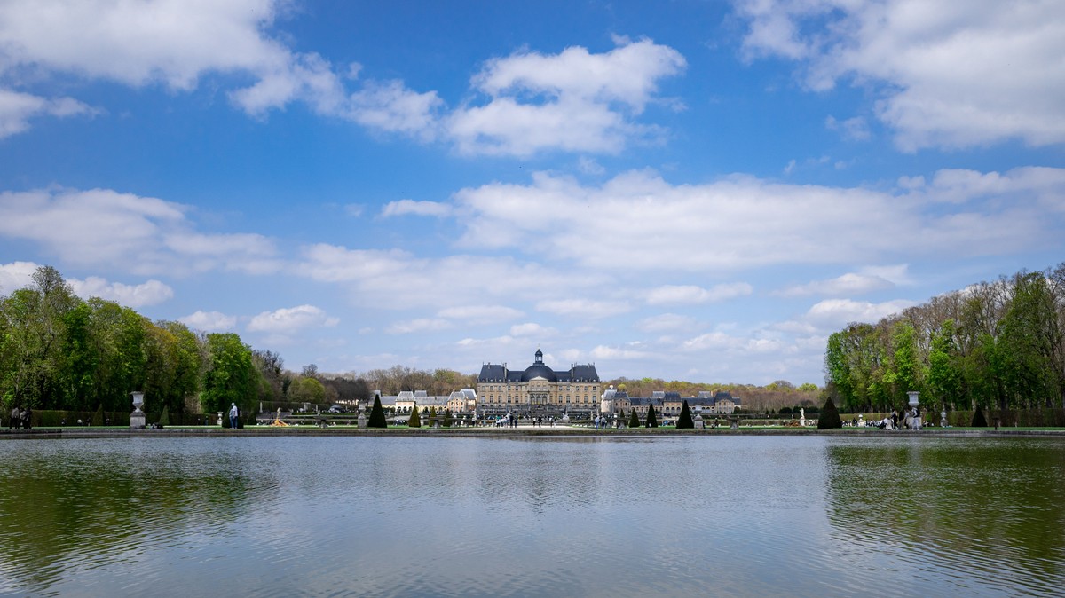 Vue du château de Vaux-le-Vicomte se reflétant dans le grand bassin des jardins à la française